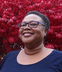 Photo of a smiling black-woman with close-cropped hair
