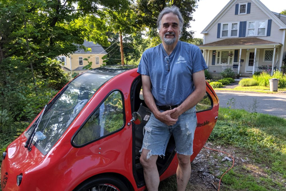 A man standing in front of a red electric bicycle