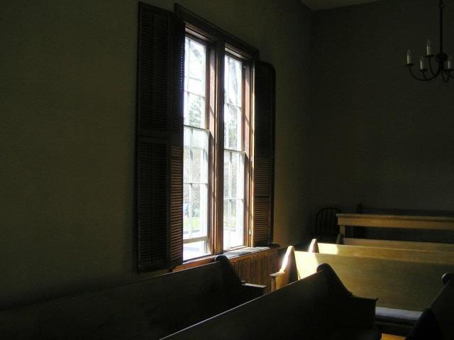 A view of a window and benches inside a Quaker meetinghouse