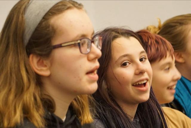 Photo shows the faces of two young girls and a boy