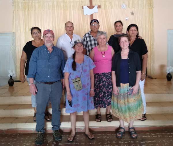 3 men and 6 women stand in front of the dais in a Cuban church