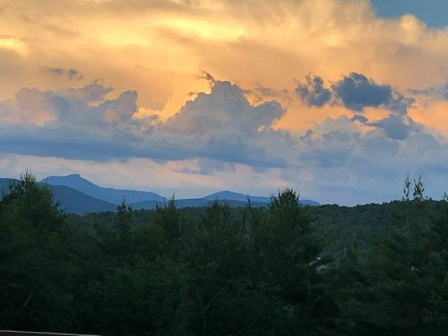 Image of a landscape with mountains and clouds lit up by sunset