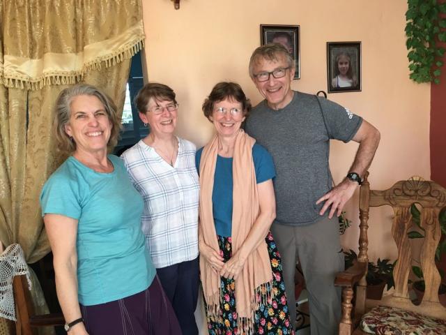 Photo of three women and one man, all smiling