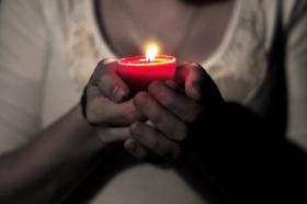 Hands holding candle