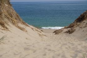 A view through sand dunes of blue ocean