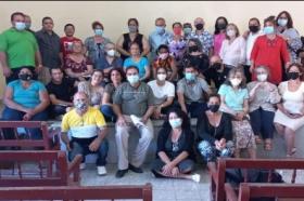 Image shows a group of about 30 people, all wearing surgical masks, posing for a group photo