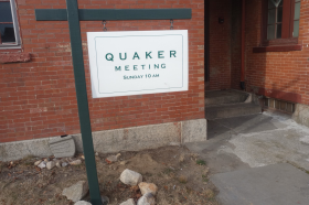 An image of a sign reading "Quaker Meeting Sunday 10 a.m."