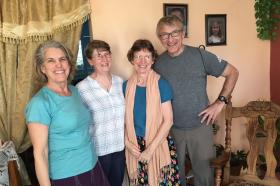 Photo of three women and one man, all smiling